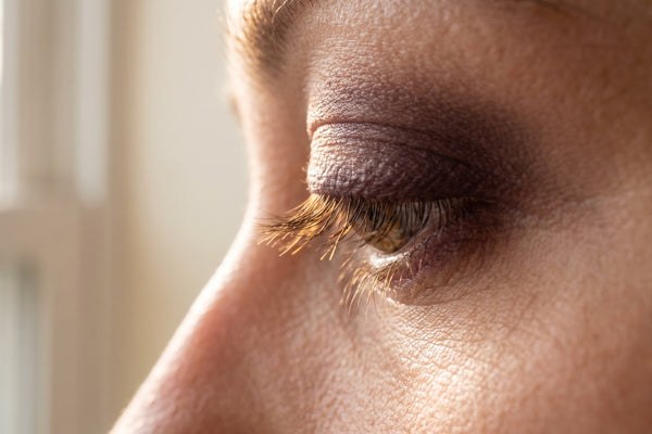 Macro d'une ligne de cils naturels sans maquillage, rétroéclairée par la lumière du matin